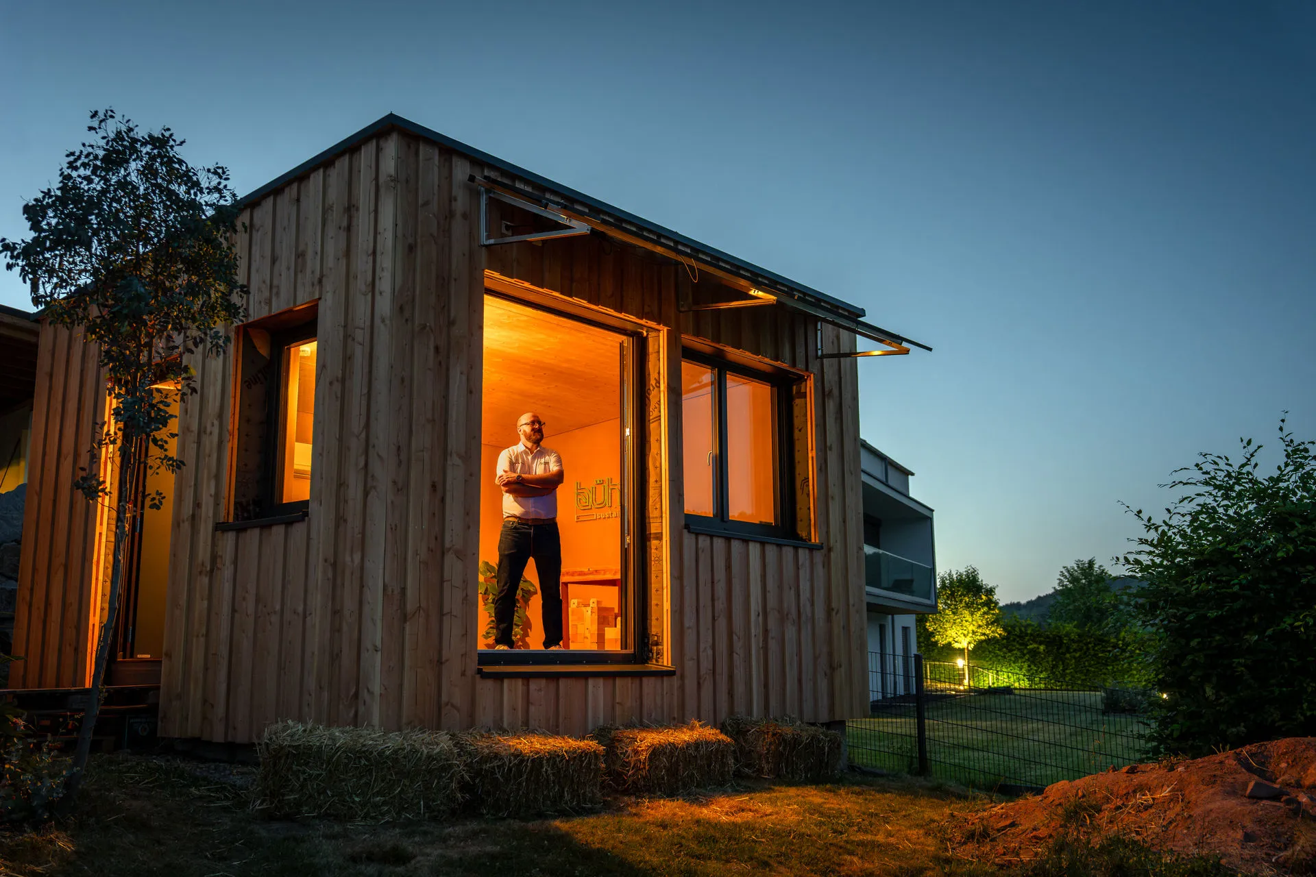 Sebastian Bühler in seinem modernen, nachhaltig gestalteten Holzgebäude mit warmer LED-Beleuchtung
